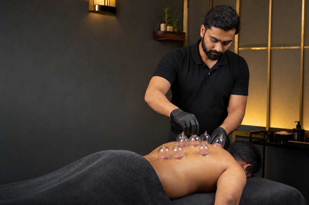 Dry cupping treatment with cups placed on the upper back